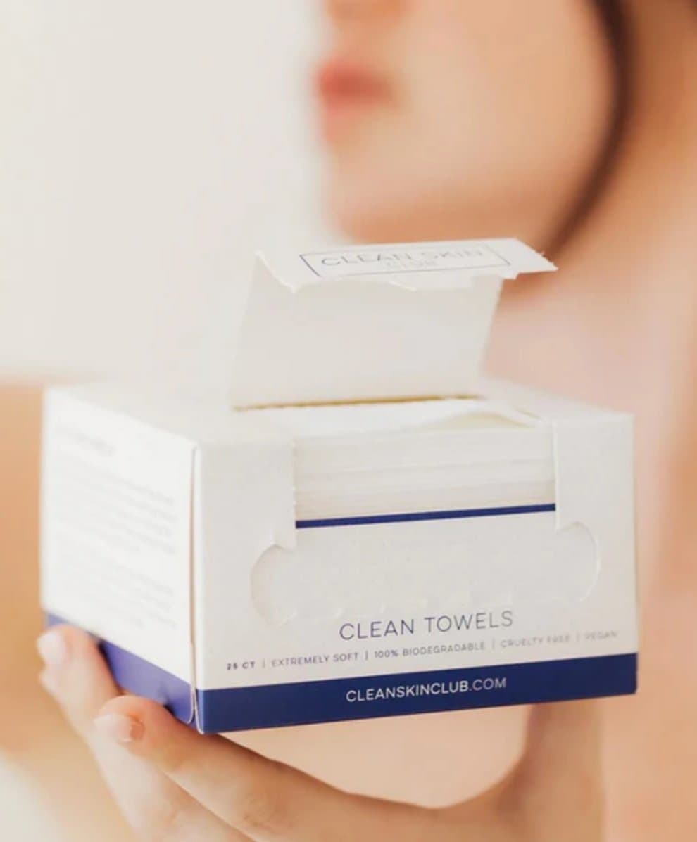 Person holding a box of Clean Skin Club towels.