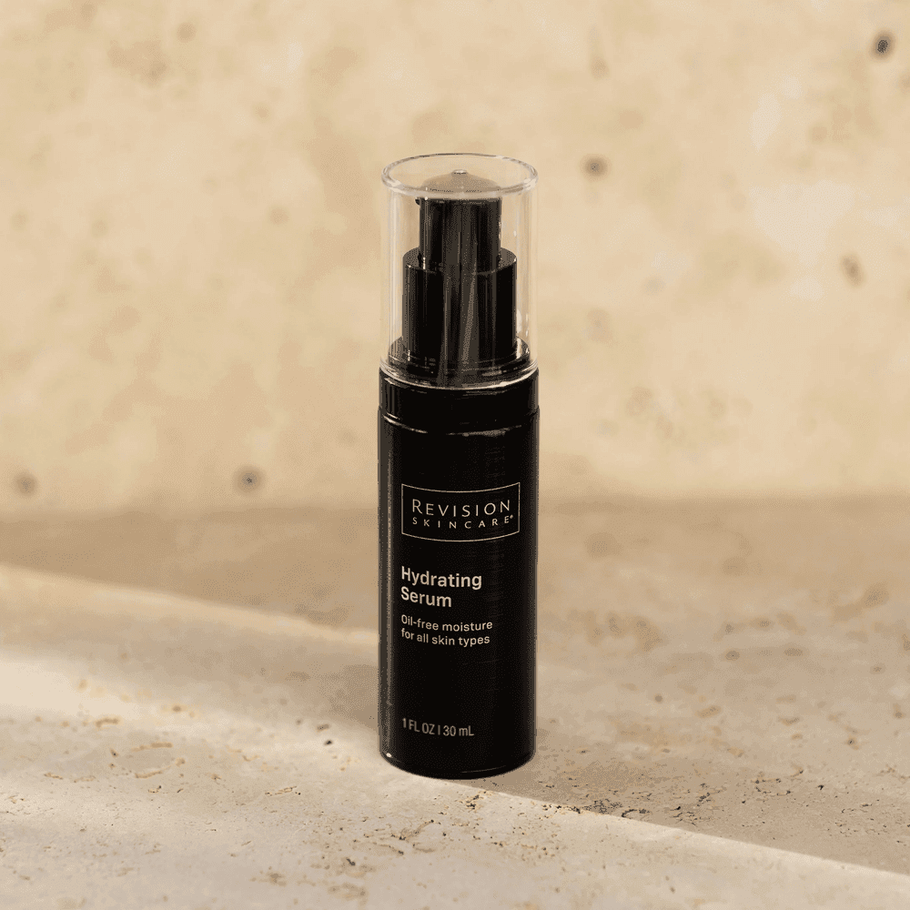 Black Revision Skincare Hydrating Serum bottle on a beige surface.